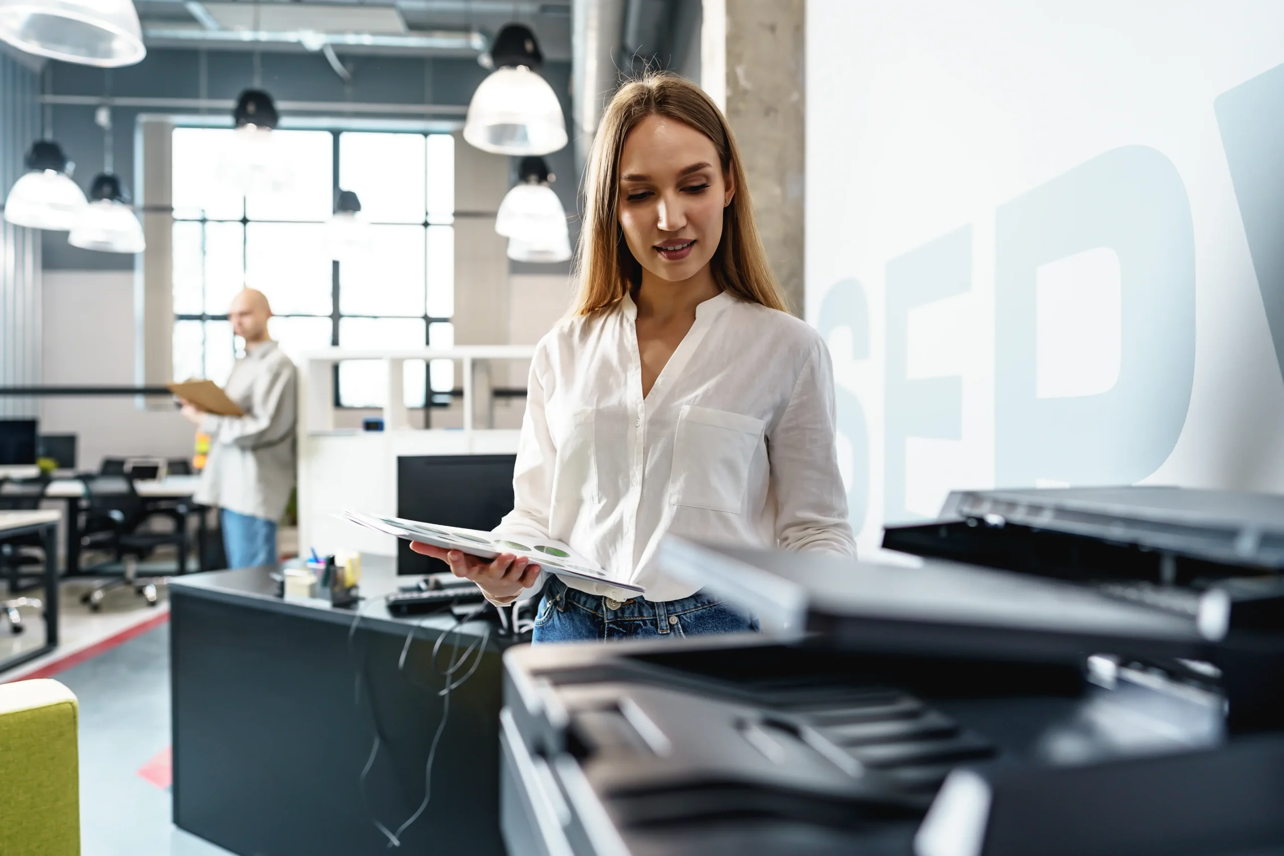 Eine junge Mitarbeiterin benutzt einen Drucker